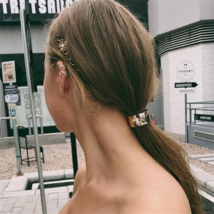 Minimalist double line crisscross ear cuff with rhinestones on model in street setting