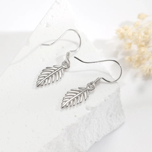Elegant 925 sterling silver leaf drop earrings on white rock with botanical decor