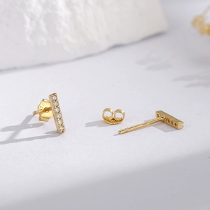 Minimalist S925 sterling silver gold bar earrings with cubic zirconia on stone surface