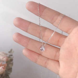 Handheld view of a minimalist S925 sterling silver necklace with a sparkling solitaire diamond