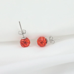 Detail of 925 sterling silver ball stud earrings with red pavé crystals on white background