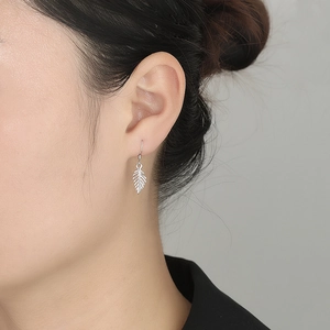 Detail shot of a 925 sterling silver leaf drop earring on a model for a delicate look