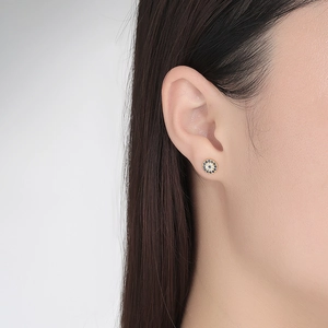 Elegant s925 silver evil eye stud earrings with blue and white crystals on a female model