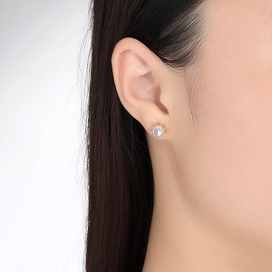 Chic gold lotus stud earrings with moonstone accents shown on a model ear