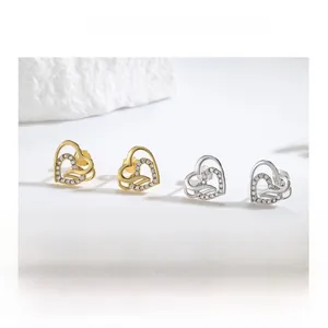 Macro view of interlocking hollow heart studs with micro-set zircon and 925 silver finish