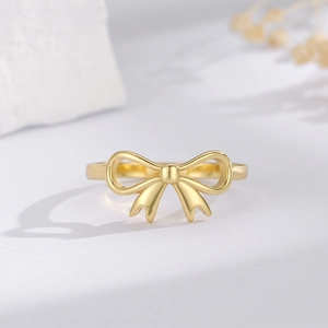 Elegante anello a fiocco in argento S925 dorato su una pietra bianca strutturata