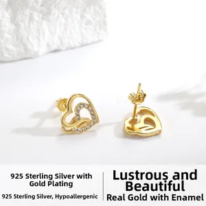 Detailed close-up of 925 sterling silver heart studs with zircon inlays and gold plating