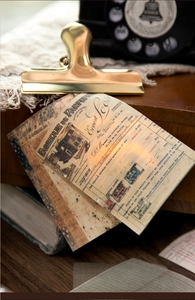 Detail of vintage scrapbooking paper set with antique receipts and brass binder clip