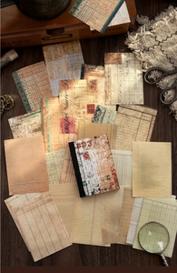 Flat lay of vintage scrapbooking paper and stickers on a dark wood background