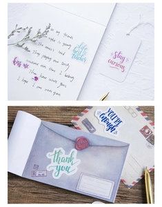 Détail de stickers artistiques pour carnet sur bureau en bois avec enveloppes