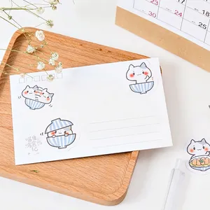 Cute hand-drawn cat themed sticker set on a wooden tray with a warm stationery background