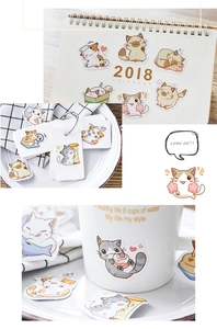 Dettagli di adesivi gatto cartone animato su calendari, biglietti e tazze in ceramica