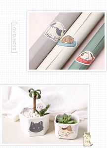 Macro detail of various cartoon cat stickers applied on paper tubes and ceramic pots
