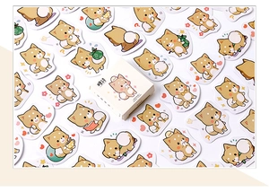Vista dettagliata di 45 adesivi Shiba Inu con vari motivi quotidiani e scatola regalo