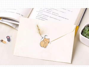 Detail of cute cat stickers on minimalist envelope with artistic desk setup decorations