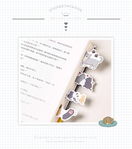 Detailed view of cat-themed stickers used as bookmarks on a book page with irregular cuts