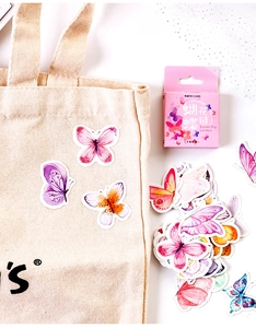 Close-up of vibrant butterfly garden stickers on a canvas bag for creative journaling
