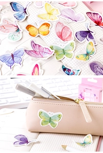 Detail of colorful watercolor butterfly stickers applied to a planner and leather pouch