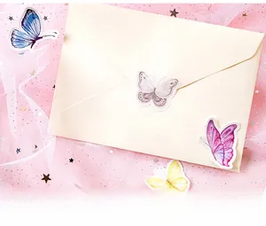 Detailed view of colorful butterfly stickers decorating a beige envelope on pink mesh fabric