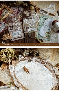 Macro view of white lace paper cutouts with intricate butterfly and leaf patterns