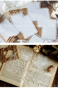 Macro shot of white laser-cut lace paper leaves and cards for DIY scrapbooking