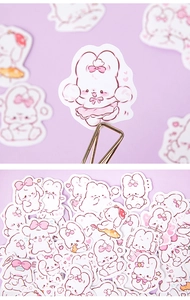 Close-up of cute rabbit stickers with pastel pink illustrations and matte paper texture