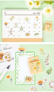 Detail of floral stickers applied to a planner and spread on a desk for DIY craft projects