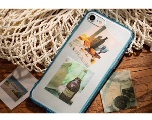 Blauw mat doorschijnend iPhone-hoesje met retro art stickers op een houten ondergrond
