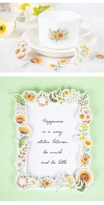 Detail showing various sunflower and daisy stickers on a white cup and green background