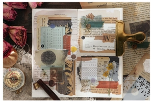 Flat lay of retro junk journal kit with torn paper, vintage stamps and floral stickers
