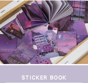Gros plan d'autocollants paysages violets avec coucher de soleil sur fond bois clair