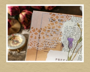 Close-up of vintage laser-cut lace paper with antique preface text for DIY scrapbooking
