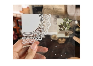 Detailed macro shot of vintage PET sticker with white lace, green leaf, and wax seal motif