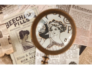 Macro view of a vintage brass magnifying glass with antique textured handle detail