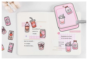 Close-up of cute pink PET stickers with dessert and drink designs on a white journal