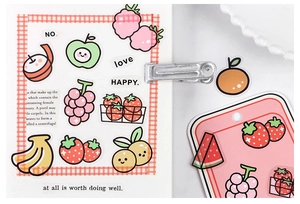 Close-up of cute cartoon fruit PET stickers on a plaid notebook with lifestyle props