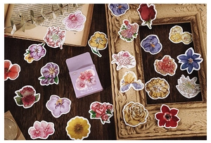 Detail of vintage flower deco stickers with elegant lavender gift box on a retro desk