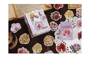 Close-up of vintage floral scrapbooking stickers with retro stationery on wood