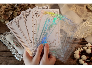 Detailed macro view of vintage DIY planner cards with PET holographic borders held by hand
