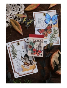Macro detail of Butterfly Forest washi stickers and vintage stationery on a wooden table