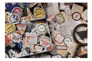 Close-up of vintage traveler-themed stickers and metal box with retro magnifying glass