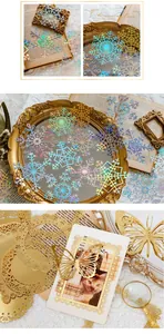 Close-up of holographic snowflake stickers and gold lace paper for DIY scrapbooking