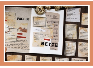 Macro view of vintage paper stickers with musical notes and retro poem script for scrapbooking