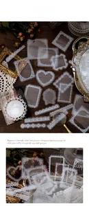 Macro shot of white vintage lace PET stickers in heart and oval shapes on dark wood