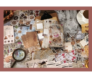 Dettaglio del set per scrapbooking vintage con adesivi retrò e carta pizzo decorativa
