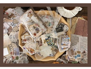 Vista dettagliata di adesivi per scrapbook vintage con motivi floreali e biglietti