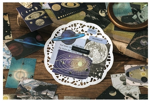 Macro shot of vintage astronomy stickers featuring Saturn, moon phases and celestial charts