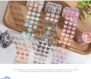 Detail of laser heart-shaped decorative tapes with colorful patterns on a wooden tray