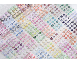 Detail of colorful heart-shaped laser-cut stickers with leopard and checkerboard patterns