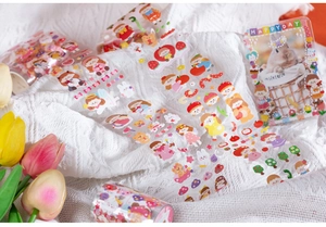Close-up of cute cartoon girl washi tape and stickers on textured white fabric background